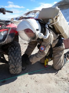 Darrel repairing Opportunity's left front tire